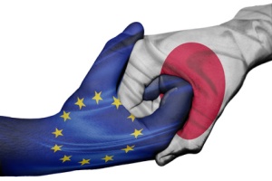 Diplomatic handshake between countries: flags of European Union and Japan overprinted the two hands